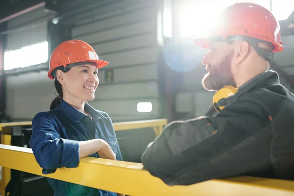 Ευτυχισμένη Νεαρή Γυναίκα Μηχανικός Hardhat Και Εργασίας Κοιτάζοντας Συνάδελφό Της — Φωτογραφία Αρχείου