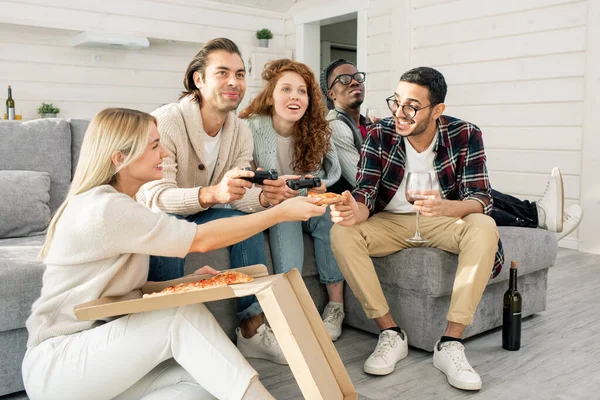 Tiro Horizontal Cinco Amigos Divirtiéndose Comiendo Pizza Jugando Videojuegos Apartamento — Foto de Stock