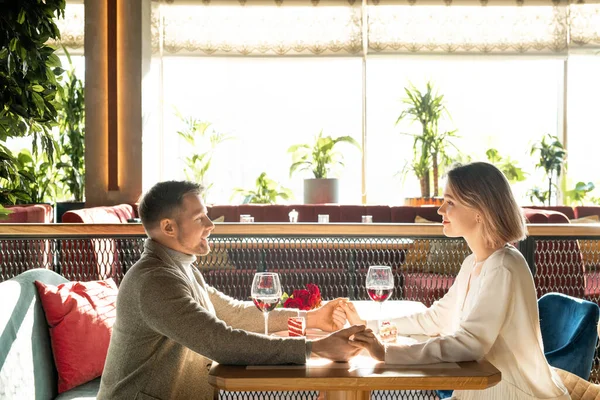 纵观快乐男女在餐馆里手牵着手坐在一起的横向画面 — 图库照片