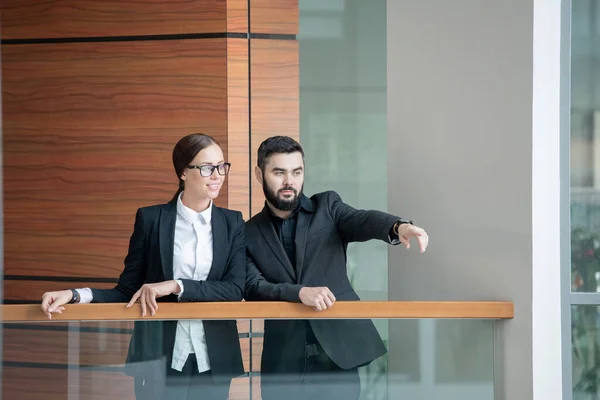 Serious Barbudo Hombre Pie Balcón Con Colega Mostrando Nueva Ubicación — Foto de Stock