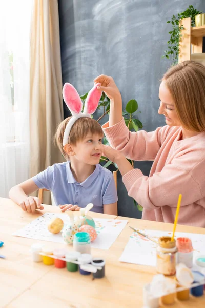 Sorridente Bella Madre Regolazione Orecchie Coniglio Fascia Del Figlio Mentre — Foto Stock