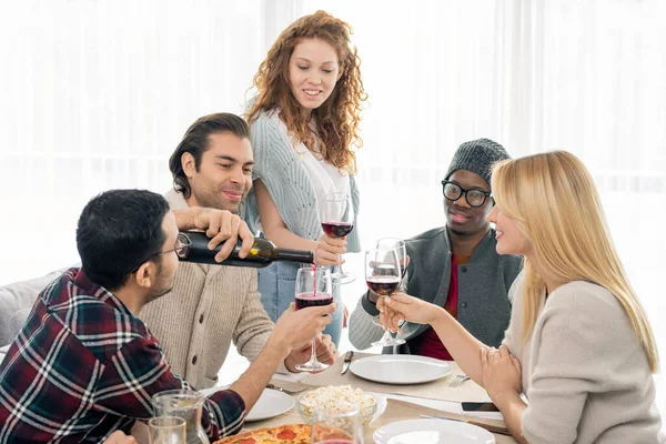 Joven Sentado Mesa Con Sus Amigos Alrededor Derramando Vino Tinto —  Fotos de Stock