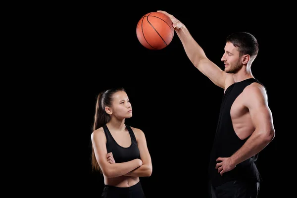 若いです筋肉バスケットボールトレーナー保持ボール上のフィットスポーツ女性見ますそれと聞きますザ男 — ストック写真