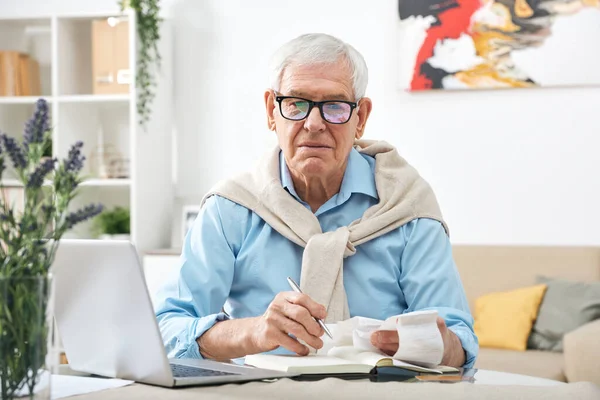 Serious Senior Man Eyeglasses Looking Payment Bills Making Notes Notebook — Stock Photo, Image