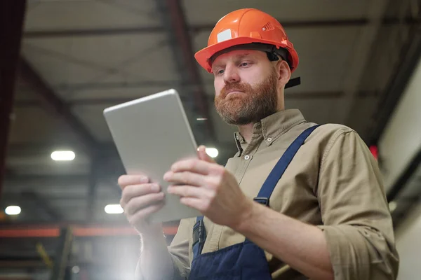 Mladý Inženýr Červeným Vousem Drží Tablet Před Sebou Při Prohlížení — Stock fotografie