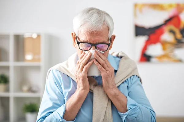 病気シニア退職した男とともにハンカチによって彼の鼻滞在に家で気分が悪く中インフルエンザ流行 — ストック写真