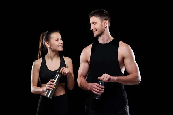 Chica Alegre Deportista Con Botellas Agua Mirándose Con Sonrisas Mientras — Foto de Stock