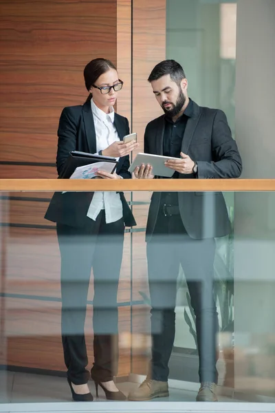 Upptagen Unga Kollegor Formalwear Stående Kontorskorridoren Och Synkroniserande Enheter Samtidigt — Stockfoto