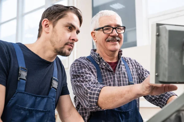 Leende Äldre Arbetstagare Med Mustasch Diskuterar Installationer Fabriksmaskin Med Ung — Stockfoto