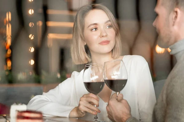 坐在餐馆里的迷人的白人妇女和男子的横向画像 他们的眼镜上挂着红葡萄酒 — 图库照片