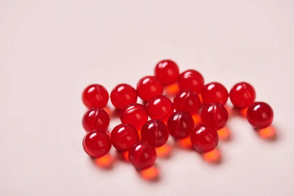 Bright Red Vitamin Drugs Pale Pink Surface Horizontal Close Shot — Stok fotoğraf