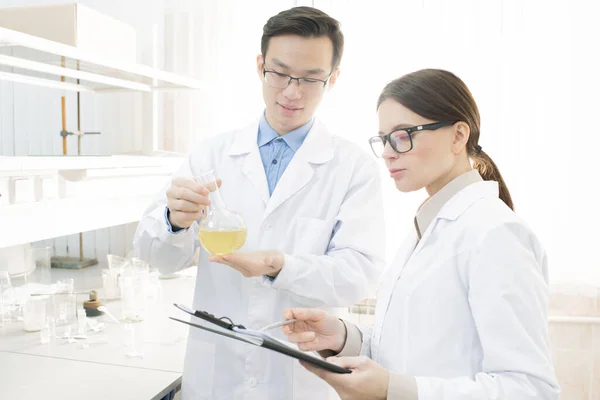 Two Young Medical Scientists White Coats Conducting Research Modern Laboratory — 图库照片