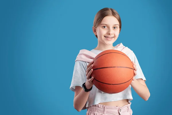 Portrét Usmívající Dospívající Dívky Držící Basketbal Modrém Pozadí — Stock fotografie