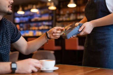 Çağdaş kafe ya da restoranın sipariş veren ve ödeme makinesine ödeme yaparken plastik kart tutan müşterisi