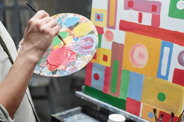 Mão Artista Masculino Com Pincel Paleta Misturando Cores Frente Tela — Fotografia de Stock