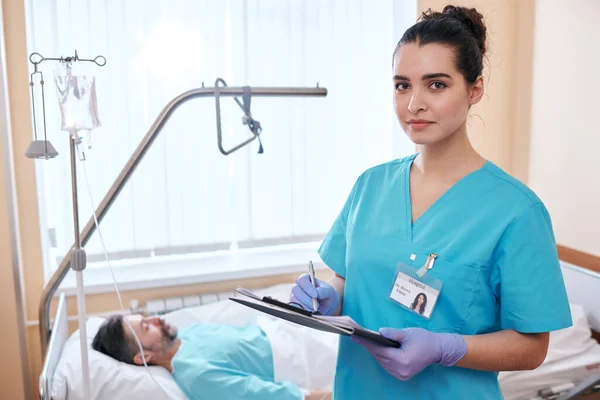 Portret Van Ernstige Jonge Verpleegkundige Chirurgische Handschoenen Die Aantekeningen Maakt — Stockfoto