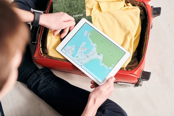 외국으로 여행을 떠나는 관광객들을 계획하면서 가방을 꾸리고 태블릿으로 온라인 지도를 — 스톡 사진
