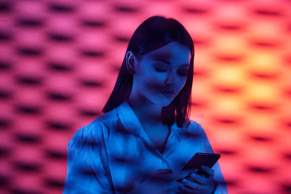 Ung Attraktiv Kvinnlig Kontorsarbetare Vit Skjorta Rulla Smartphone Neon Bakgrund — Stockfoto