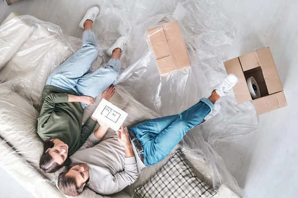 Rahat Giyimli Genç Çiftin Yeni Evlerinin Planlarını Tartışırken Kanepede Oturması — Stok fotoğraf