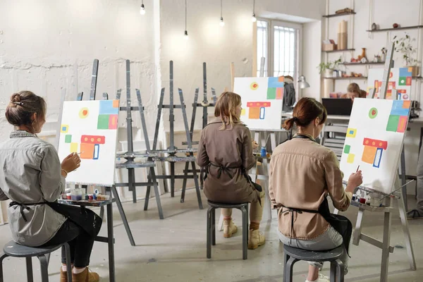 Vista Trasera Varias Alumnas Clase Pintura Sentadas Sillas Delante Caballetes —  Fotos de Stock