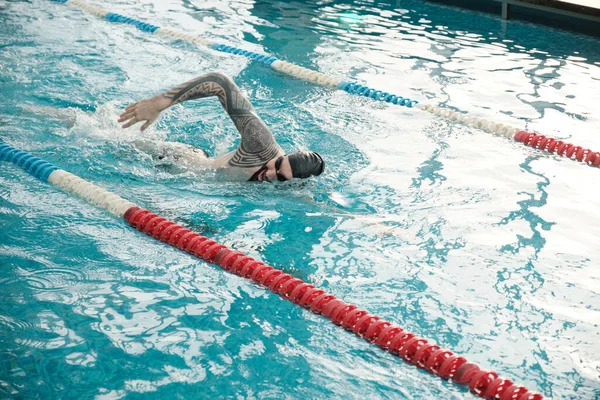 Junger Bärtiger Mann Mit Mütze Und Brille Schwimmt Modernem Schwimmbad — Stockfoto