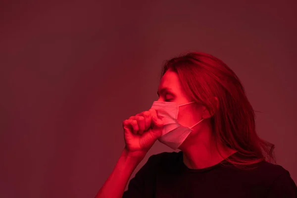 若いです病気女性とともにCovid19で保護マスク咳で彼女の顔によって彼女の顔上の暗いですバックグランドで隔離 — ストック写真