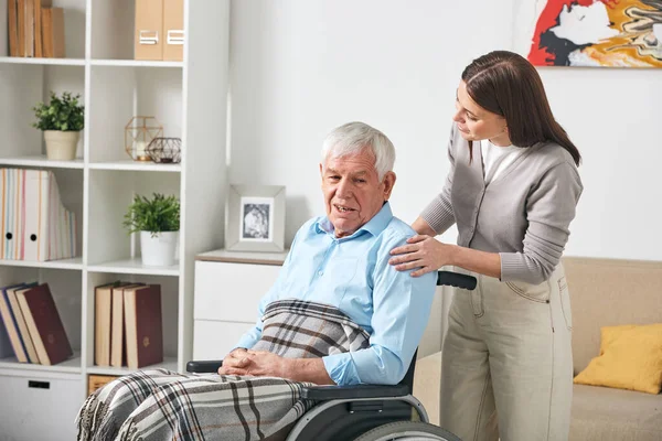 Careful Young Nurse Talking Elderly Man Wheelchair While Visiting Him — Stock Photo, Image