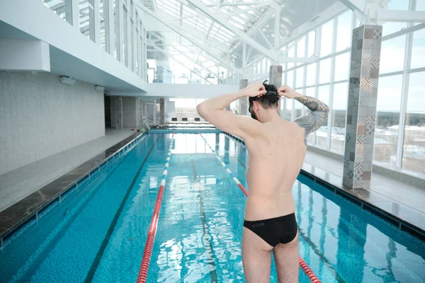 Achteraanzicht Van Atletische Man Met Tatoeage Aanpassen Bril Tijdens Voorbereiding — Stockfoto