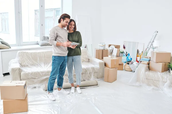 Jonge Casual Paar Staan Bij Bank Woonkamer Van Hun Nieuwe — Stockfoto