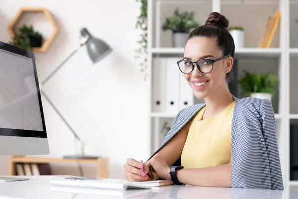 Szczęśliwa Młoda Bizneswoman Smart Casual Patrząc Ciebie Siedząc Przy Biurku — Zdjęcie stockowe