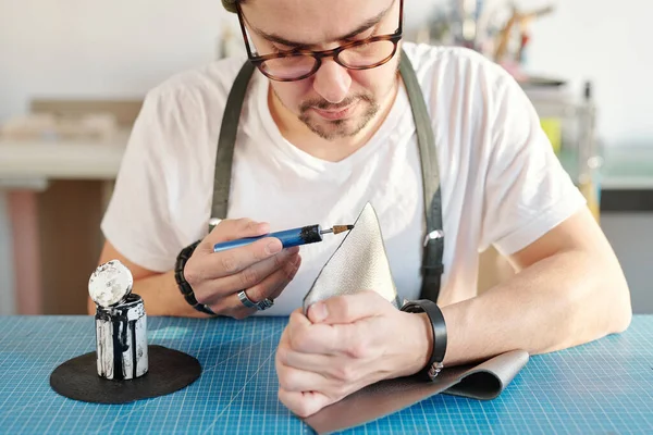 Young Serious Creative Leatherworker Applying Black Paint Edge Piece Grey — Stock Photo, Image