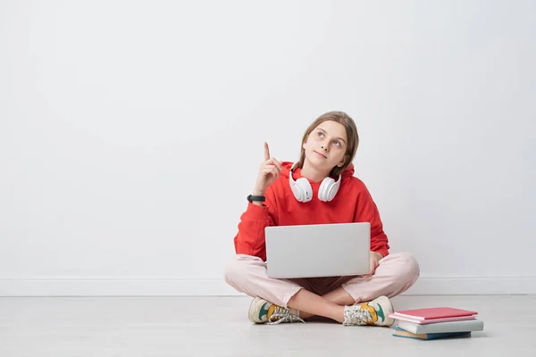 Docela Chytré Zkřížené Teenager Ukazuje Nahoru Zatímco Sedí Podlaze Vedle — Stock fotografie