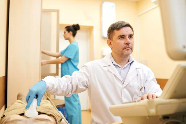 Laboratuvar Önlüklü Ciddi Bir Olgun Doktor Hastanın Karnını Incelerken Ultrason — Stok fotoğraf