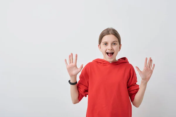 穿着红色运动衫的友善快乐的少女 张开手掌看着你 对你的白种人背景表示高兴 — 图库照片