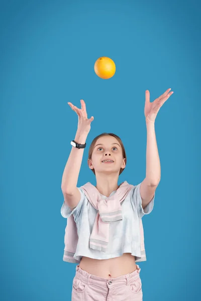 Energetisches Teenager Mädchen Wirft Frische Orange Während Vor Der Kamera — Stockfoto