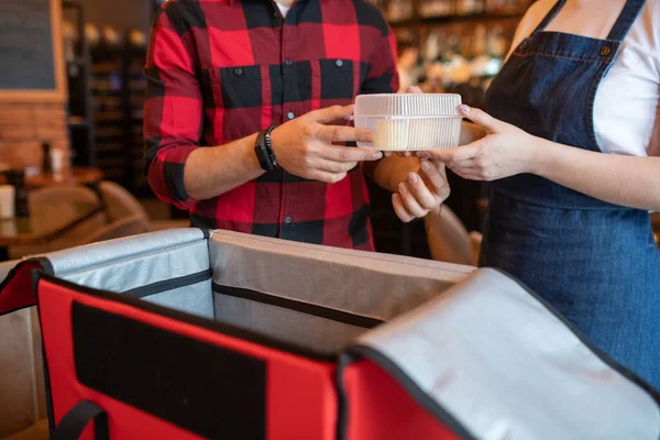 咖啡店服务员带着顾客的订单经过塑料容器 一边打开大红包 一边打包订餐 — 图库照片