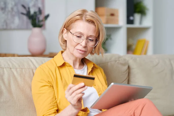 Rijpere Blonde Vrouw Bril Casualwear Kijken Naar Credit Card Terwijl — Stockfoto