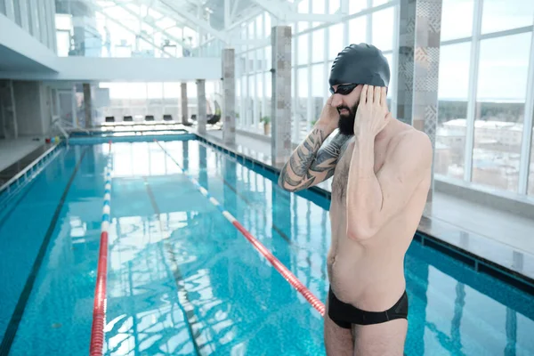 Yüzme Şapkası Takmış Kulaklarını Yüzmeye Hazırlayan Yakışıklı Sakallı Bir Adam — Stok fotoğraf