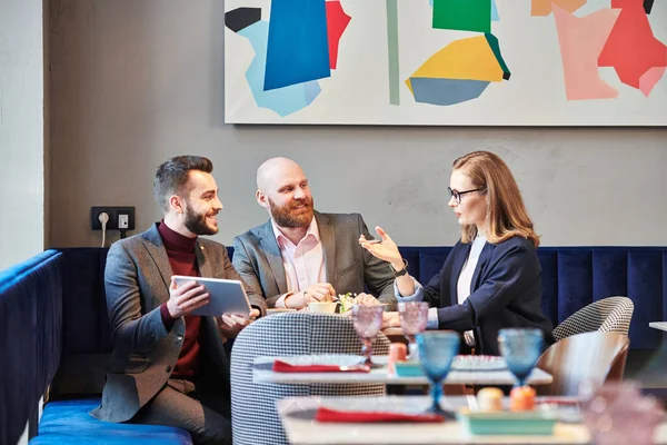 Grupo Colegas Negócios Sentados Mesa Restaurante Usando Tablet Durante Discussão — Fotografia de Stock