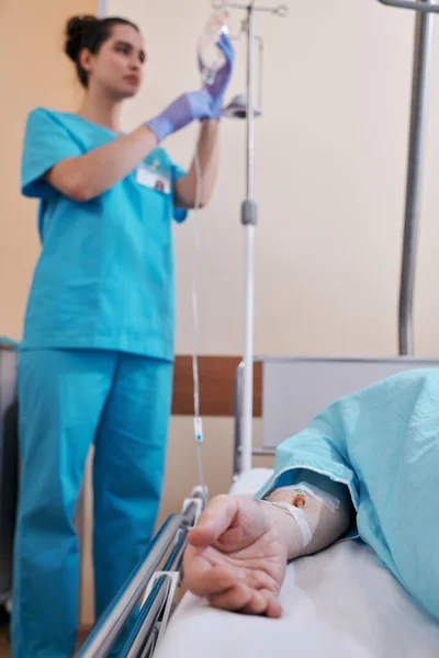 Pielęgniarka Wisząca Worek Stoisku Podczas Podawania Płynów Dożylnych Choremu Pacjentowi — Zdjęcie stockowe