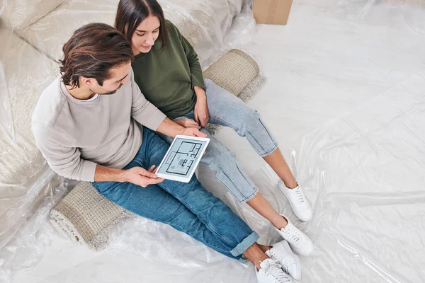 Junge Eheleute Betrachten Den Plan Ihrer Neuen Wohnung Auf Dem — Stockfoto