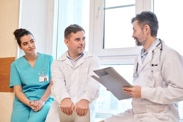 Bärtiger Arzt Mit Stethoskop Den Hals Gespräch Mit Kollegin Über — Stockfoto