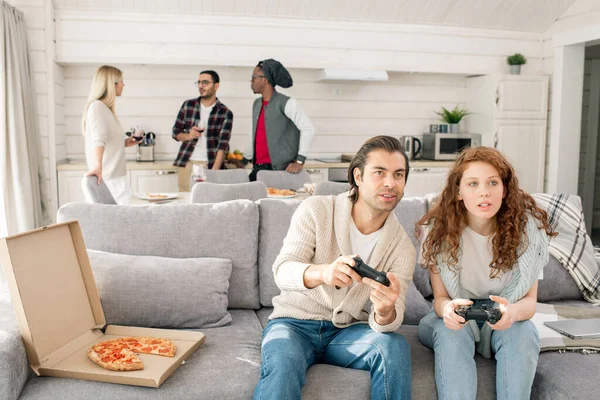 Pareja Joven Con Joysticks Sentados Sofá Delante Televisión Jugando Videojuegos — Foto de Stock