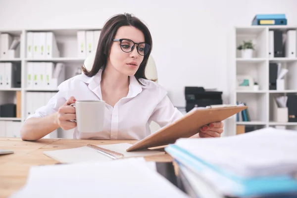 Busy Young Office Woman Sitting Table Reading Papers While Drinking — Stock Photo, Image