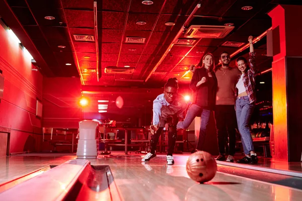 Afrikai Srác Hajlítás Bowling Sikátorban Miközben Dobott Labdát Háttér Barátai — Stock Fotó