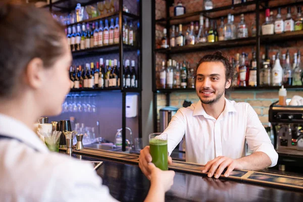 Happy Young Barman Holding Glass Vegetable Cocktail Smoothie Client While — Stock Photo, Image