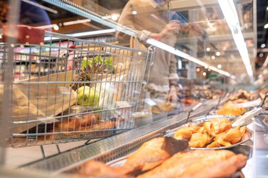 Tütsülenmiş balık ve diğer deniz ürünleri gastronomisi süpermarkette ve vitrinin arkasında yiyecek ürünleri olan alışveriş arabasında geniş bir ekran oluşturuyor.