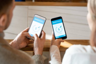 Çevrimiçi bankacılık üzerinden para gönderme ve alma operasyonunda akıllı telefonlu iki genç flörtün elleri