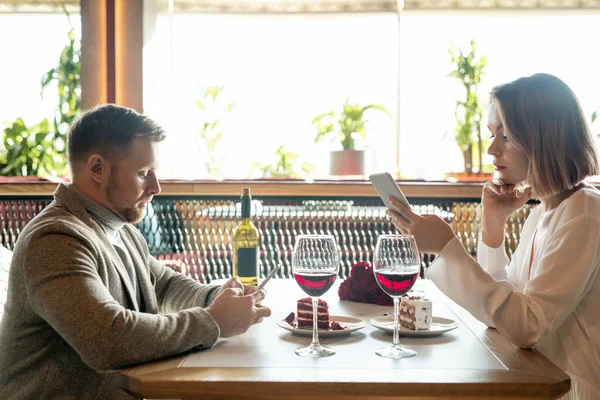 Jovens Datas Contemporâneas Rolando Seus Gadgets Enquanto Sentado Mesa Com — Fotografia de Stock