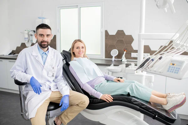 Mujer Rubia Feliz Paciente Joven Dentista Exitoso Whitecoat Guantes Sentados — Foto de Stock